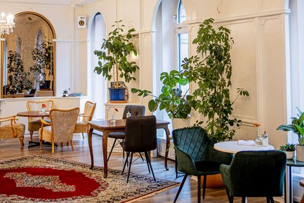 Innenraum des Café Zanetta mit viel Tageslicht an den Fenstern, gemütlichen Sesseln und Platz für Feiern