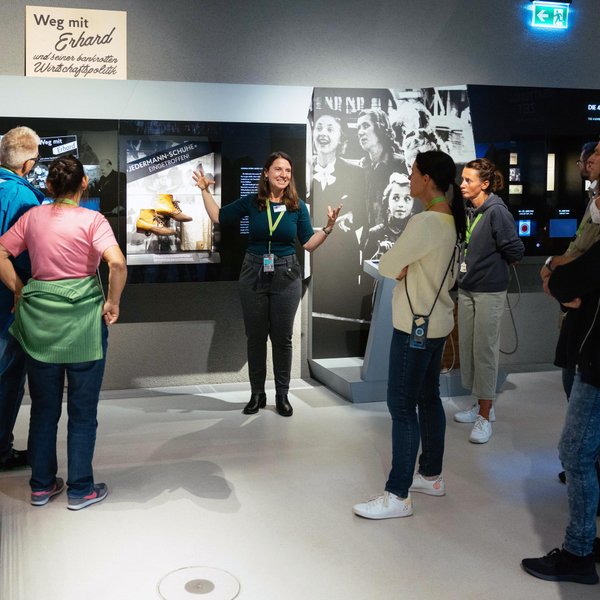 Gruppe nimmt an Stadt(ver)führungen teil und erkundet das Ludwig Erhard Zentrum mit Holztürmchen-Bändern