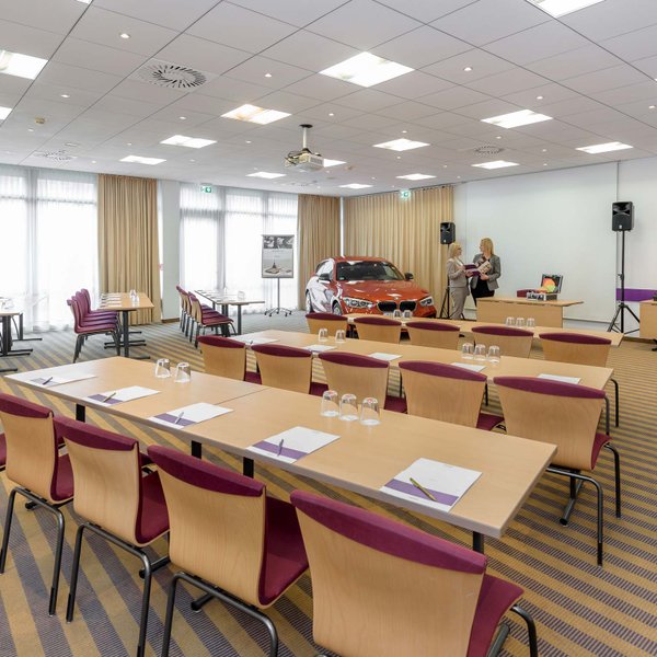 Heller Tagungsraum im Mercure Hotel Nürnberg West mit Reihenbestuhlung, Tischen und Präsentation