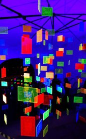 Buntes Acrylglas-Mobile mit quadratischen, leuchtenden Platten und unterschiedlichen Motiven.