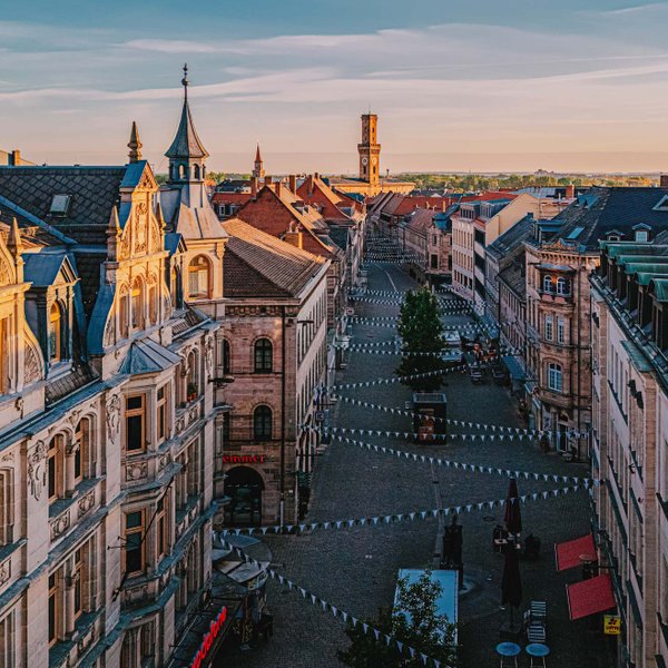 Panorama der Fürther Fußgängerzone mit Sandsteinhäusern und Blick auf das Rathaus mit Turm