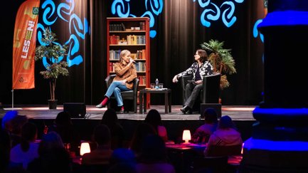 Julia Engelmann spricht auf der Bühne im Kulturforum Fürth, Publikum und blau beleuchtete Säulen sichtbar.