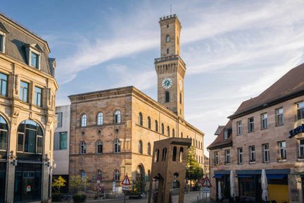 Blick auf das Fürther Rathaus mit Rathausturm, leicht von der Sonne angestrahlt.