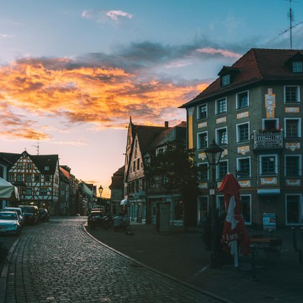 Die Sonne geht über der Fürther Altstadt unter und taucht die Dächer in warmes Abendlicht