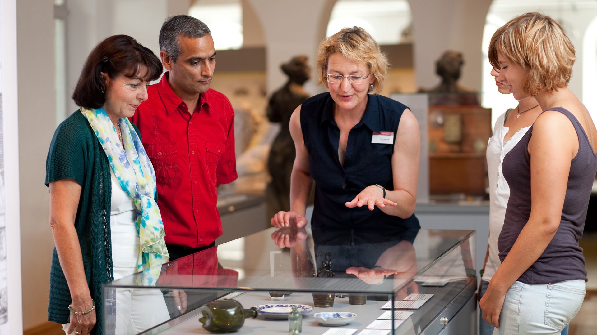 Museumsführerin erklärt einer Gruppe am Schaukasten die Ausstellung beim Stadtspaziergang „Fürth – kompakt & anschaulich“.