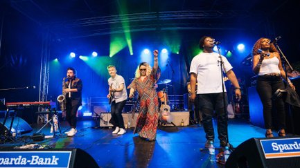 Live-Band spielt auf dem New Orleans Festival auf einer farbig beleuchteten Bühne