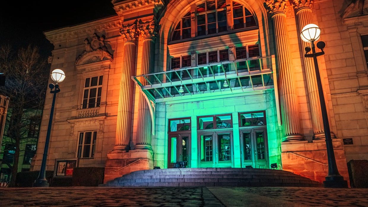 Reich verzierte historische Stadttheater-Fassade mit großem Bogen, Säulen und Büsten berühmter Künstler.