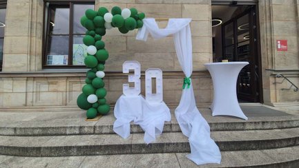 Aufsteller mit der Zahl 30 und Luftballon-Girlande vor dem Eingang der Tourist-Information Fürth.