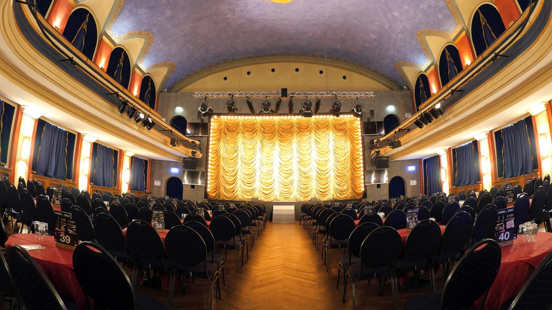 Die Bühne der Comödie Fürth ist vorbereitet, der Vorhang verhüllt die Sicht und das Licht setzt alles gekonnt in Szene.