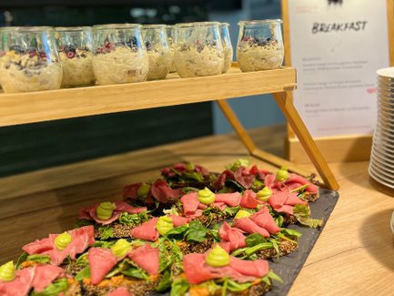 Frühstücksbuffet mit belegten Broten und Süßspeisen in Gläsern