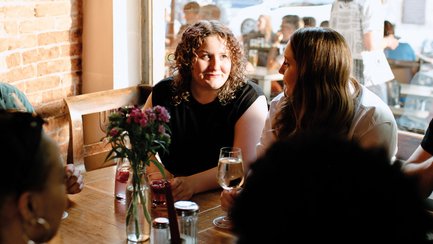Zwei Frauen sitzen an einem Tisch in einem Restaurant in Fürth und führen ein Gespräch