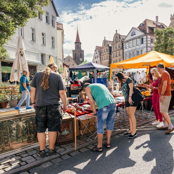 Besucher schlendern zwischen Flohmarktständen mit Antiquitäten auf dem Graffelmarkt