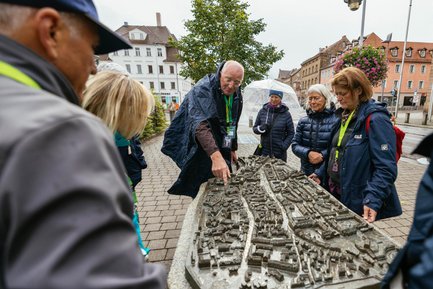 Menschen ertasten den taktilen Stadtplan am Fürther Rathaus bei einer inklusiven Stadtführung