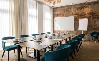 Heller Tagungsraum Freiraum im Werners Boutique Hotel Fürth mit Sandsteinwand, Tischen, Stühlen und Flipchart