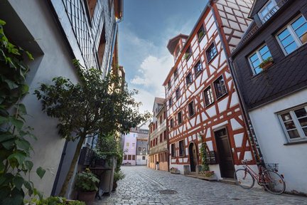 Enges Pflastergässchen mit historischen Fachwerkhäusern, Schieferfassaden und abgebildetem Fahrrad.
