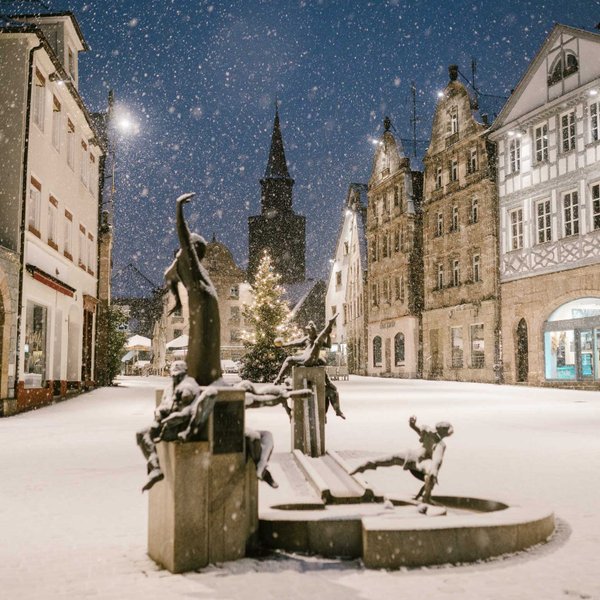 Schneebedeckter Grüner Markt mit Gauklerbrunnen im Vordergrund und Fachwerkhäusern im Hintergrund