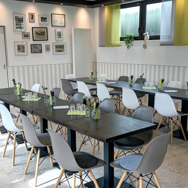 Mehrere zusammengestellte Tische im Frankies Hofladen mit Gläsern, Blumendeko und Wandbildern