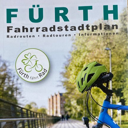Cover des offiziellen Fahrradstadtplans Fürth mit einem blauen Fahrrad und neongrünem Helm.