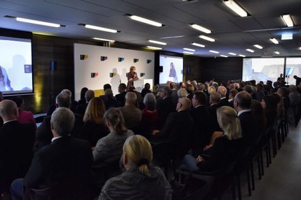 Veranstaltungsraum im Ludwig Erhard Zentrum mit besetzten Stuhlreihen und einer Rednerin vorne