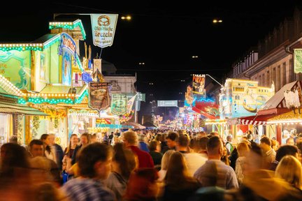 Abendliche Fürther Kirchweih mit stimmungsvoll leuchtenden Buden und dicht gefüllter Straße voller Menschen.