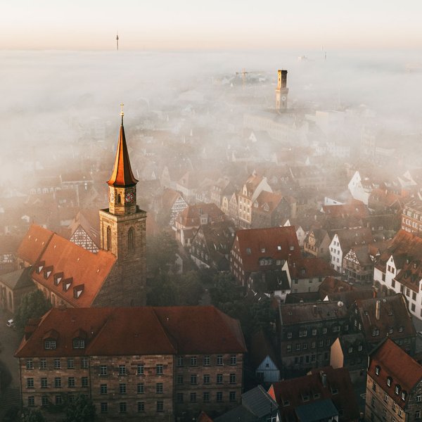 Morgenstimmung über Fürth: Dächer, der Rathausturm und Kirchtürme ragen aus einer dichten, weißen Nebeldecke.
