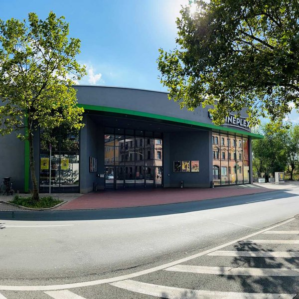 Modernes Cineplex Fürth mit langgezogenem Gebäude, blauem Himmel und einladendem Eingangsbereich