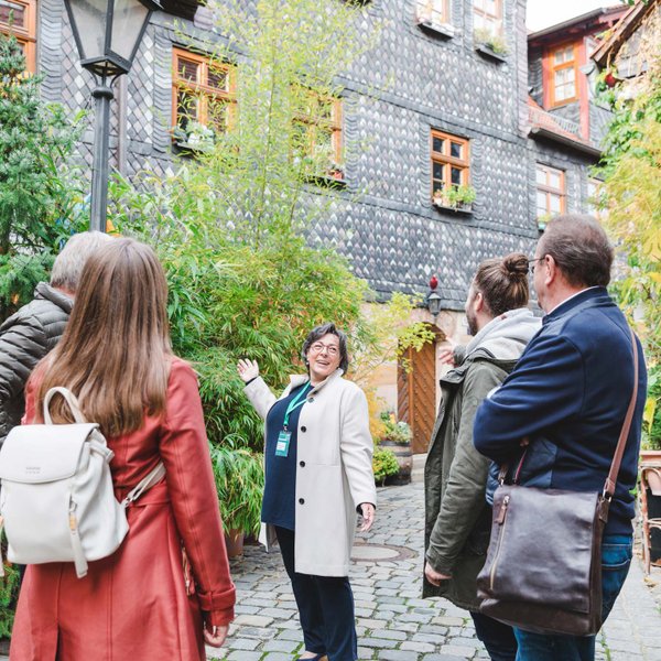 Gruppe lauscht einer Stadtführerin in einem historischen Altstadthof in Fürth während einer Führung.