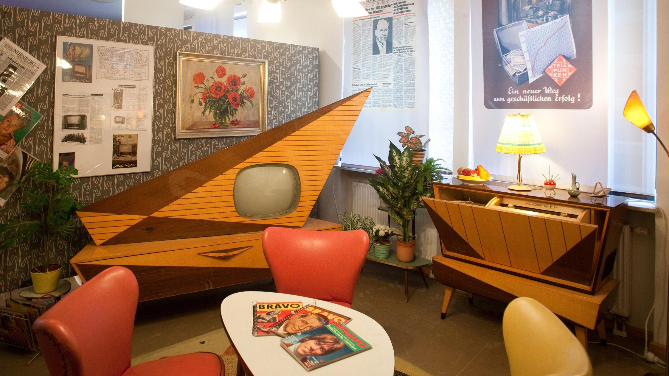 Ein Wohnzimmer im Retro-Stil mit alten Möbeln, Rundfunkgeräten und Zeitschriften im Rundfunkmuseum.