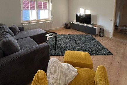 Gemütliches Wohnzimmer mit Eckcouch und Fernseher in der Ferienwohnung B8 im Landkreis Fürth