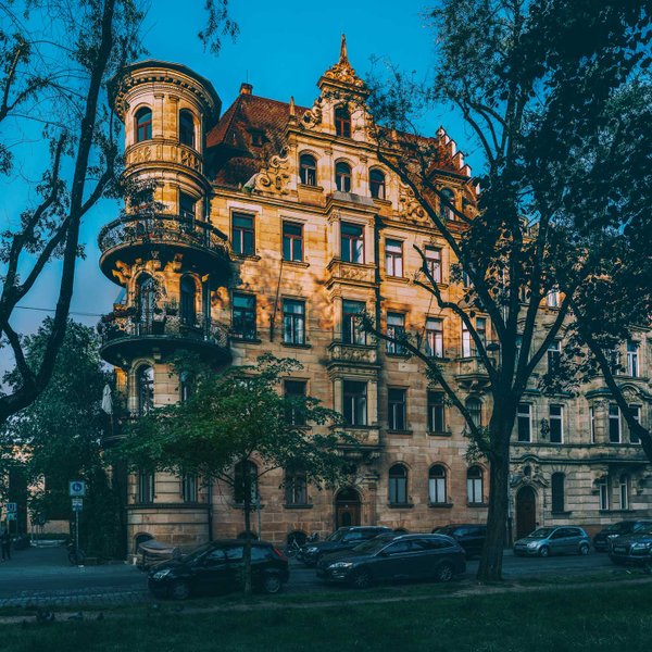 Sandsteinfassaden der Königswarterstraße in Fürth unter blauem Himmel im warmen Sonnenlicht