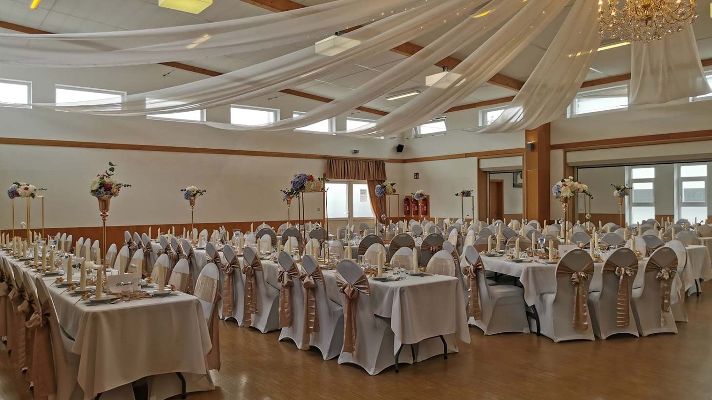 Festlich gedeckte Eventhalle in Fürth-Burgfarrnbach mit dekorierten Tischen und Kronleuchtern