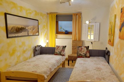 Gemütliches Schlafzimmer mit zwei Einzelbetten und gelben Akzenten in der Ferienwohnung Anita Pfeiffer im Landkreis Fürth