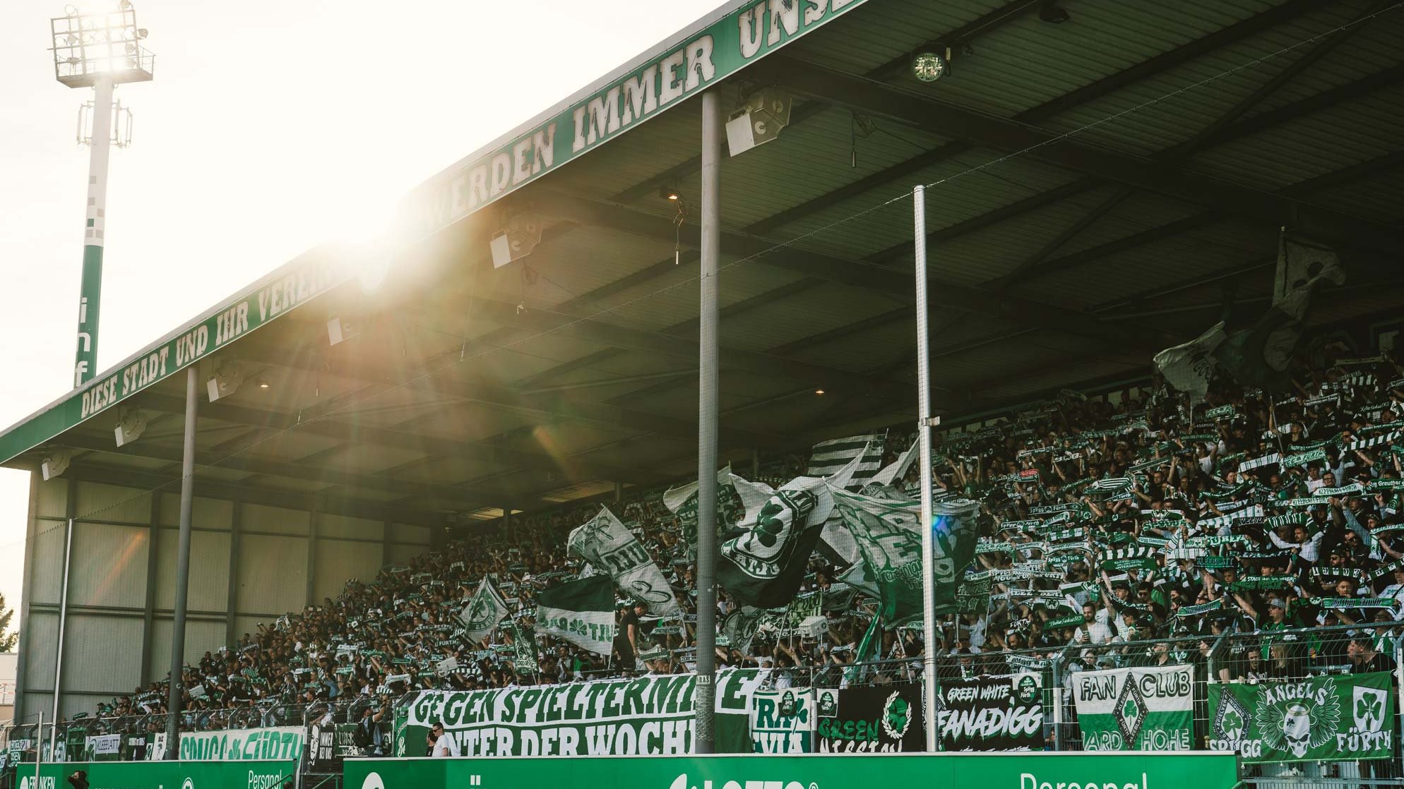 Volles Stadion mit jubelnden Fans, Fahnen und Bannern beim Heimspiel von SpVgg Greuther Fürth.