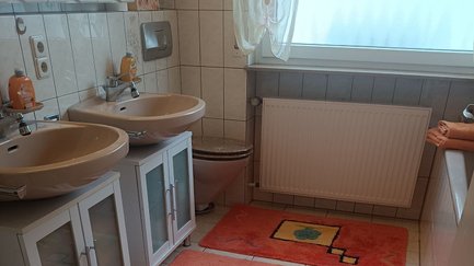 Modernes Badezimmer im Apartment Angelika mit zwei Waschbecken und WC