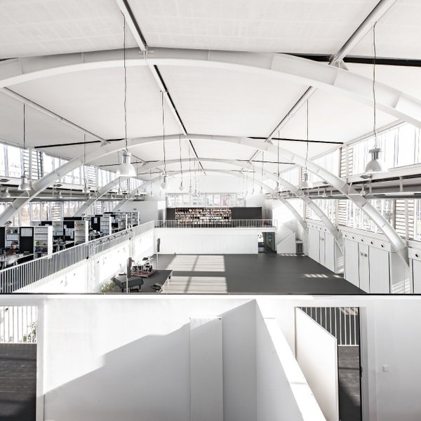 Helle Grüne Halle Fürth mit zwei Ebenen: offene Arbeitsplätze oben, leere Halle unten, weißes Interieur