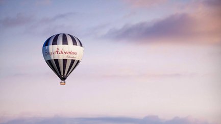 Ein Heißluftballon von Sky Adventure schwebt ruhig am Himmel