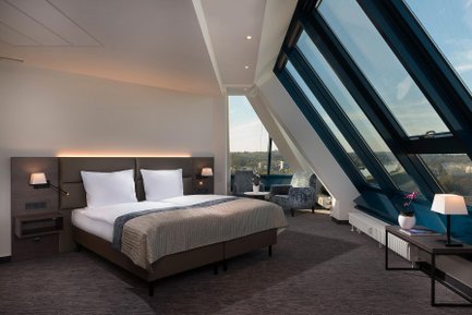 Großes Doppelbett in einem stilvoll eingerichteten Zimmer des Excelsior Hotels Nürnberg Fürth