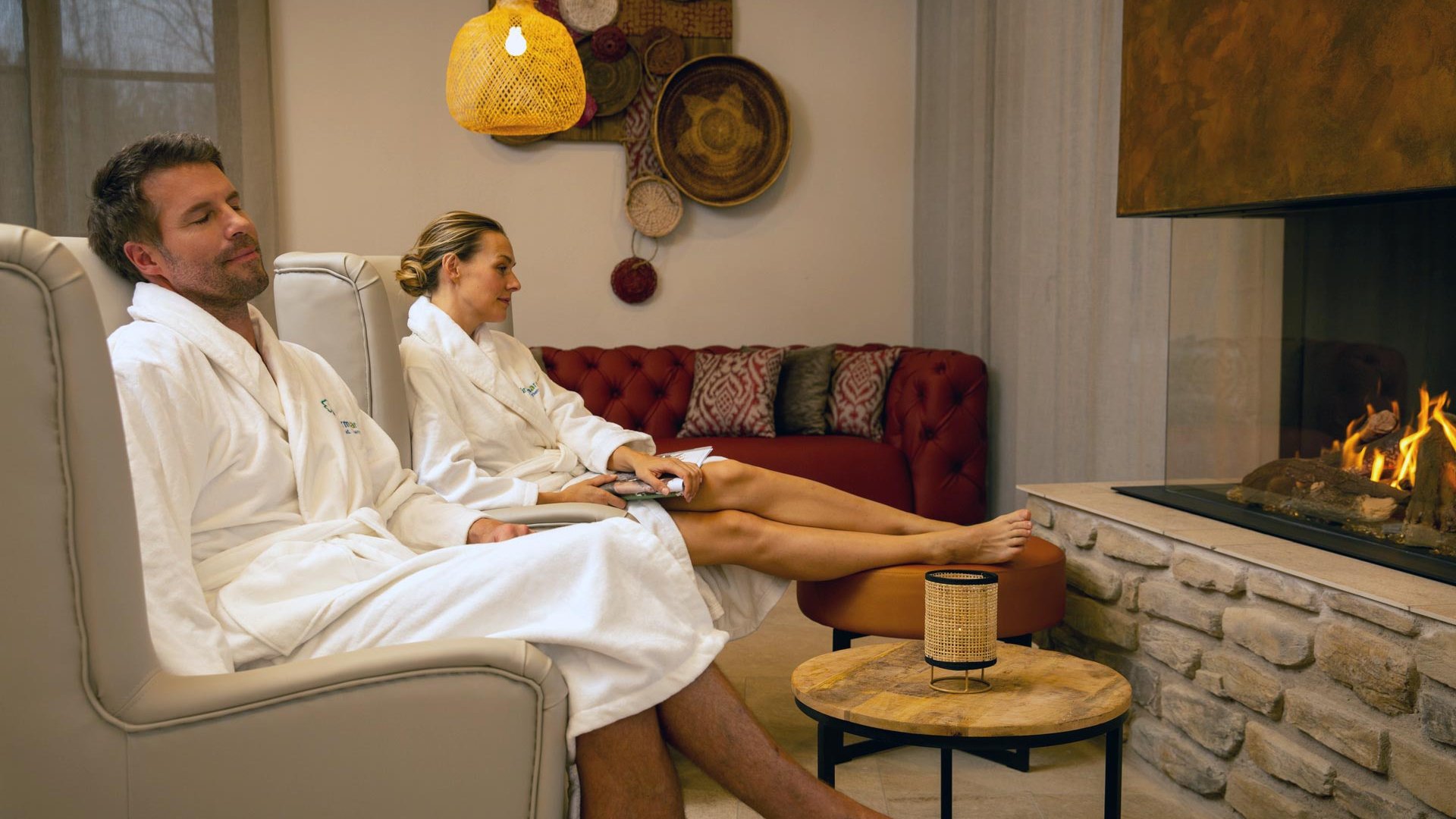 Ein Pärchen entspannt im Saunabereich des Fürthermares vor dem Kamin und genießt eine Auszeit. 