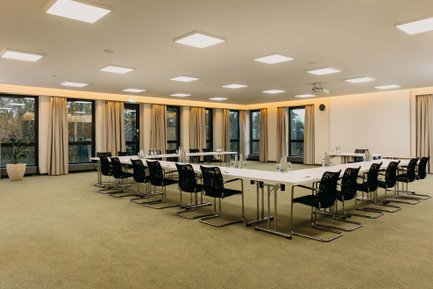 Geräumiger Konferenzraum im Hotel Forsthaus Fürth mit Teppichboden, Rechteckbestuhlung und vielen Fenstern