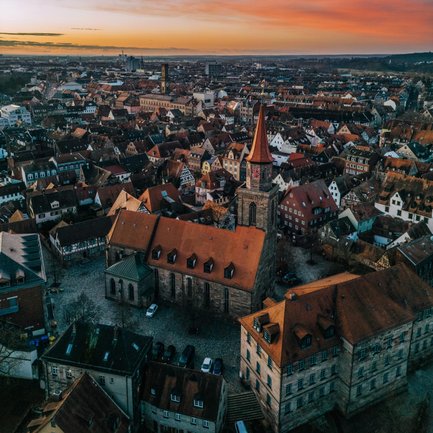 Morgenlicht fällt auf die Dächer der Fürther Altstadt, dahinter ragen die Türme von Rathaus und St. Michael