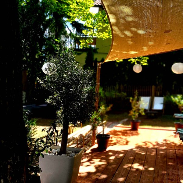 Sonniger Außenbereich des Alten Forsthauses in Fürth mit karierten Tischdecken Lampions und entspannter Atmosphäre