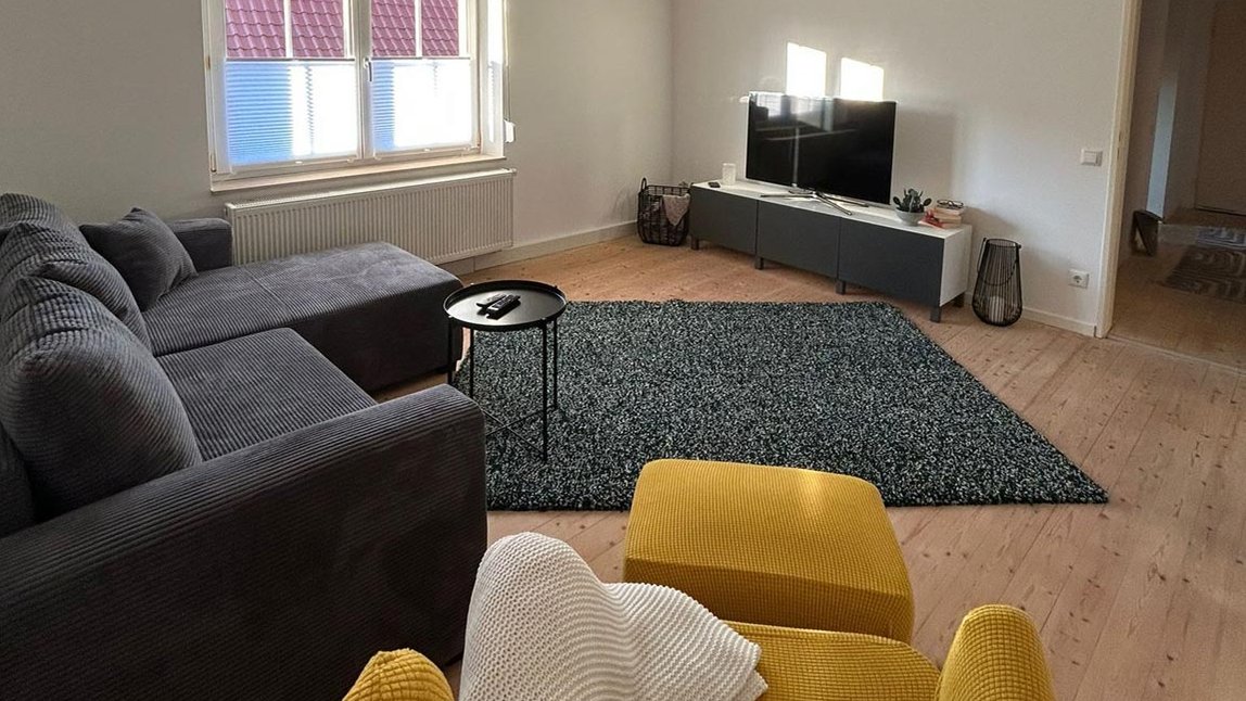 Gemütliches Wohnzimmer mit Eckcouch und Fernseher in der Ferienwohnung B8 im Landkreis Fürth