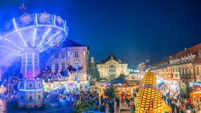 Abendliche Michaelis-Kirchweih mit Kettenkarussell, Buden, Losständen und Besuchern vor dem Stadttheater.