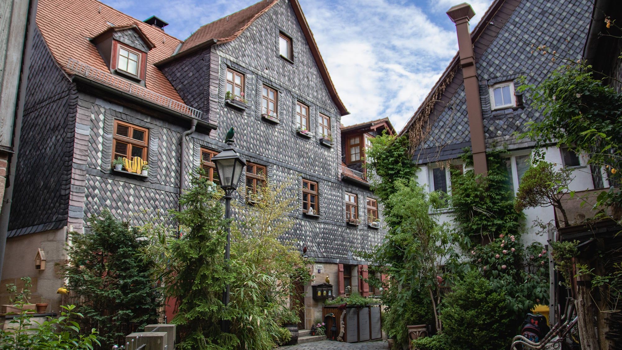 Die Pfarrgasse in Fürth zeigt ihre historischen Schieferfassaden, liebevolle Deko und grünen Altstadtcharme