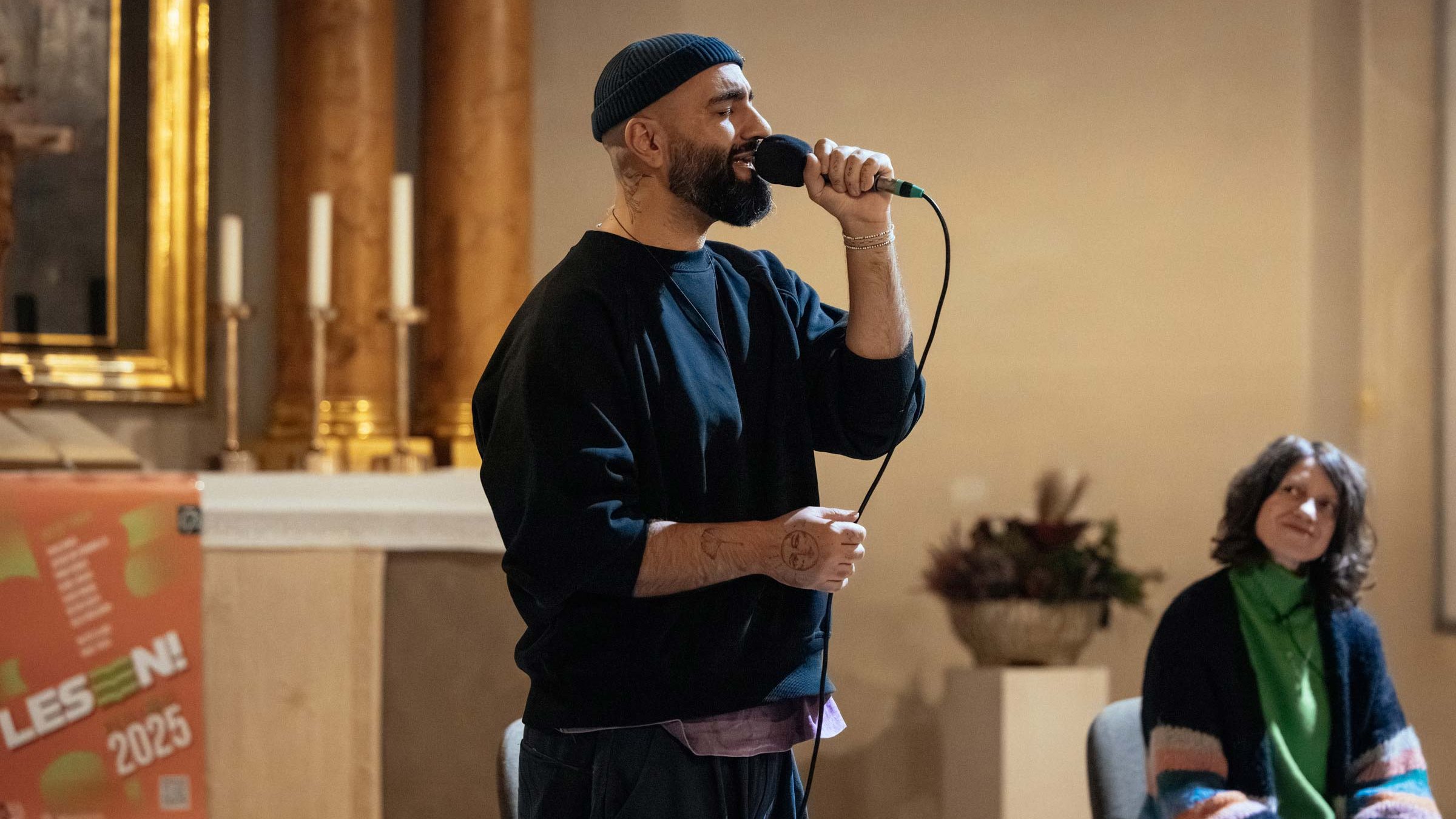Person mit Mikrofon auf einer Kirchenbühne während eines Beitrags beim Lesen! Literaturfestival