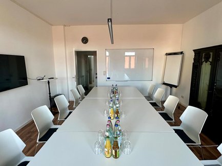 Heller Seminarraum Fürth mit Konferenztischen, Whiteboard und Apple TV für bis zu 12 Personen