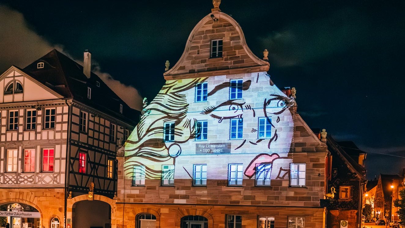 Am Grünen Markt wird bei den Fürther Glanzlichtern eine blonde Comicfigur auf den Goldenen Schwan projiziert