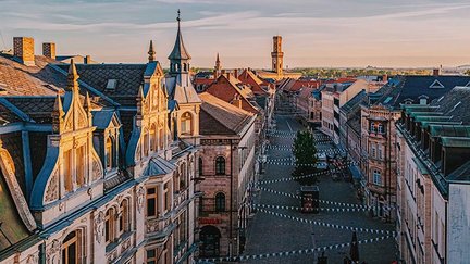 Panoramablick auf die Fürther Fußgängerzone mit Fähnchen, prunkvollen Sandsteinhäusern und Rathaus im Hintergrund