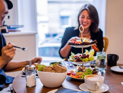 Detailaufnahme eines gedeckten Tisches im Café Zanetta mit Etagère, Früchten, Aufstrichen und Cappuccino