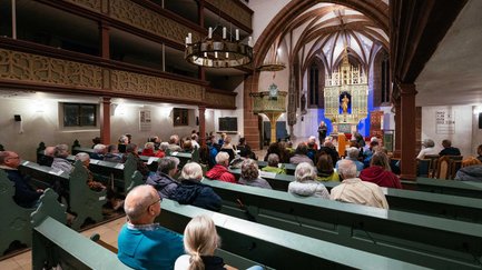 Besucher sitzen in einer historischen Kirche bei einer Veranstaltung der Stadt(ver)führungen.